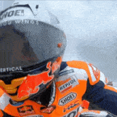 a motorcycle racer is wearing a helmet with the word shoe on it