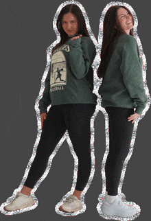 two girls are posing for a picture and one has a sweatshirt that says baseball on it