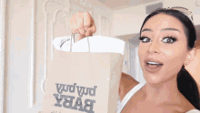 a woman is holding a brown paper bag that says " vud vud "