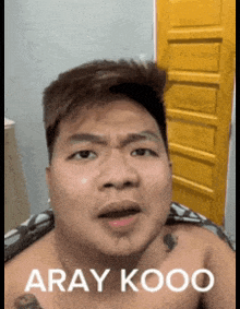 a shirtless man with a tattoo on his chest is making a funny face and says aray kooo on the bottom