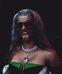 a woman with blue hair and red sunglasses is sticking her tongue out