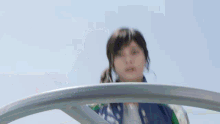 a girl is riding a ferris wheel with a blue sky behind her