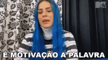 a woman with blue hair is wearing a striped shirt and a turtleneck and is talking in a foreign language .