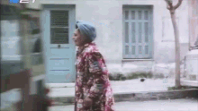 a woman in a turban is walking down the street .