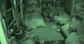 a group of people are sleeping in a room with a lot of pillows on the floor