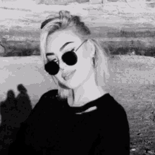 a black and white photo of a woman wearing sunglasses and earrings