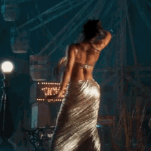 a woman in a dress is dancing in front of a sign that says tickets