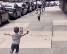 a little boy is running down a sidewalk with a monkey on the side of him
