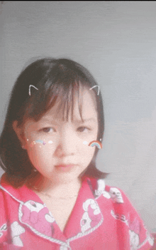 a little girl with a sticker on her face that says rainbow