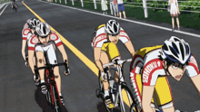 a group of people are riding bicycles down a road and one of them has the word shoku on their jersey
