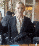 a woman is sitting at a table holding a black bag .