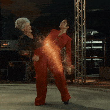 a woman in a red dress is being attacked by another woman in a black dress