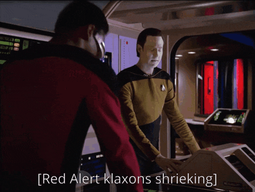 two men looking at a computer screen with the words danger will robinson on it