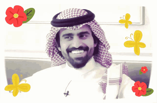 a man with a beard wearing a head scarf and a white shirt is smiling with flowers and butterflies around him