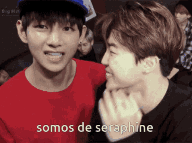 two young men are standing next to each other and one of them is wearing a red shirt that says somos de serphine