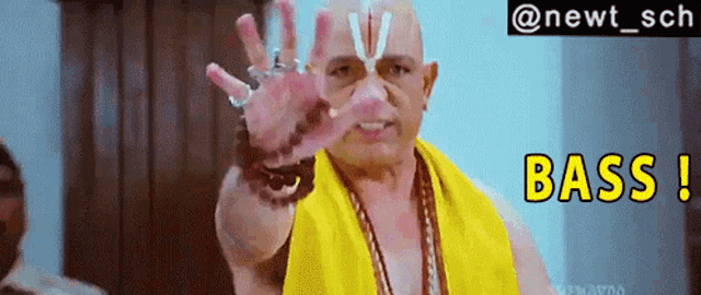 a bald man wearing a yellow towel is making a funny face and says " bass " in yellow letters