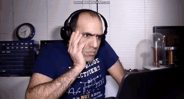 a man wearing headphones and a blue shirt that says " it is nut "