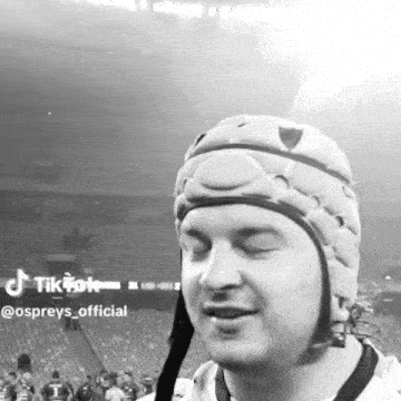 a black and white photo of a man wearing a helmet with tiktok sprays_official written in the corner