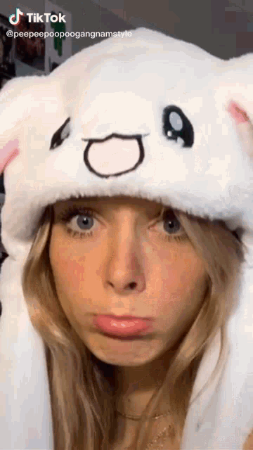 a woman wearing a white hat with a face drawn on it is a tiktok video