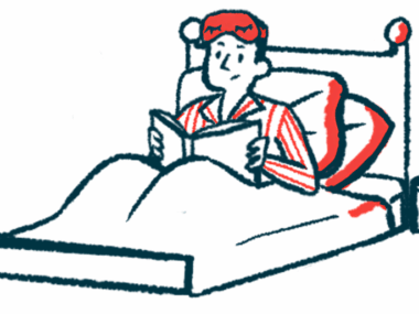 A person in pajamas sits in a bed reading a book.