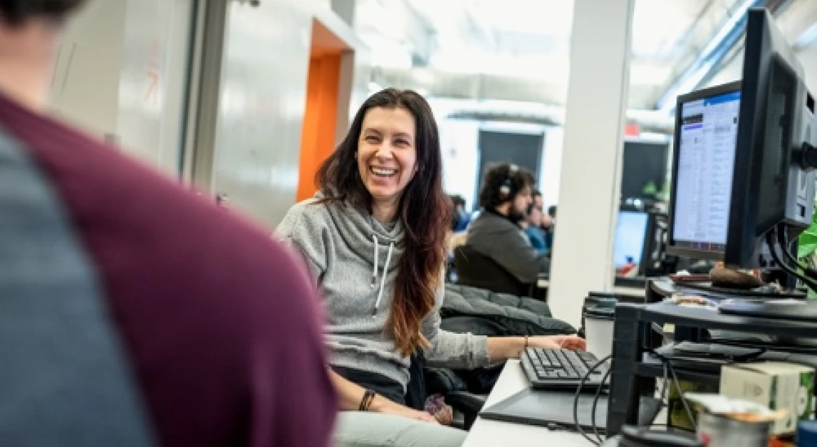 A woman smiles at coworker in an office