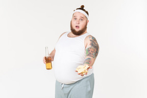 一个胖男人穿着运动服拿着一瓶啤酒和分享筹码