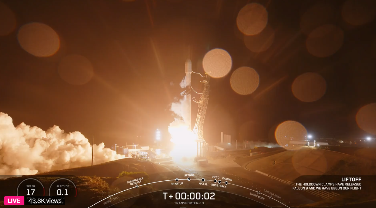 A rocket lifts off from a launch pad at night