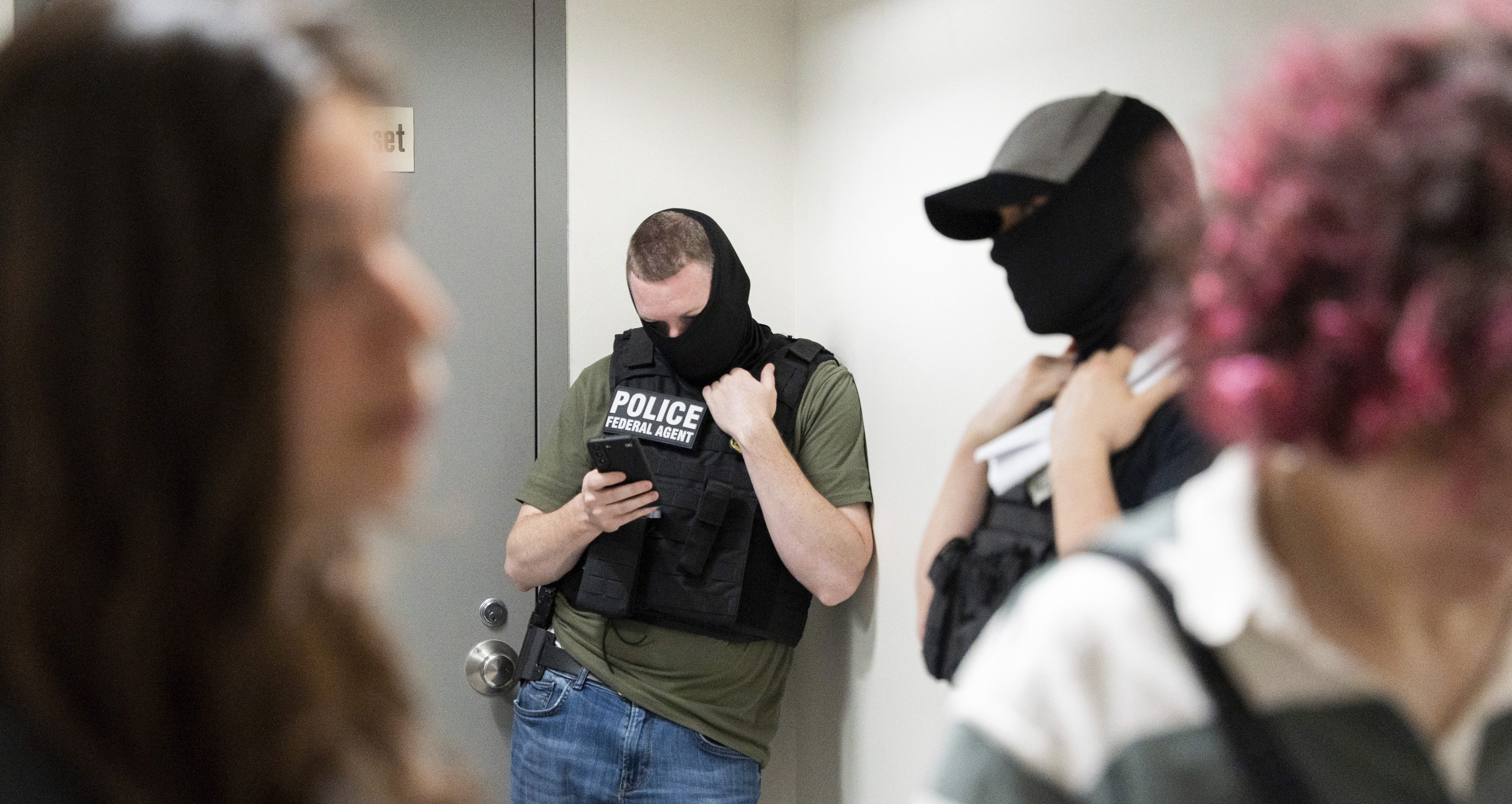 ICE agents are seen waiting outside a courtroom in the hallway of federal immigration court in Lower Manhattan, NY on Friday, June 20, 2025.