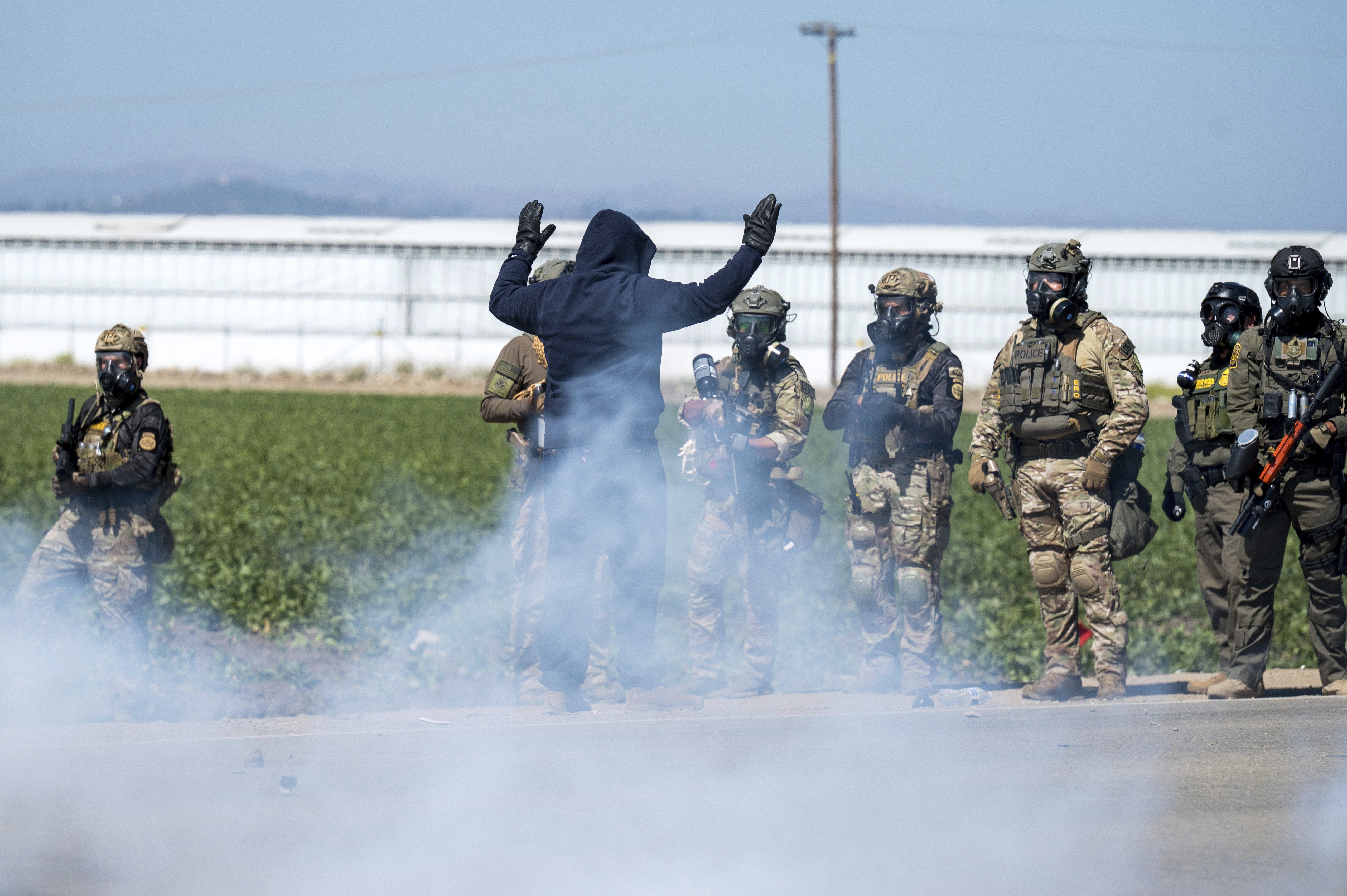 Federal immigration agents toss tear gas at protesters during a raid in the agriculture area of Camarillo, Calif., Thursday, July 10, 2025.