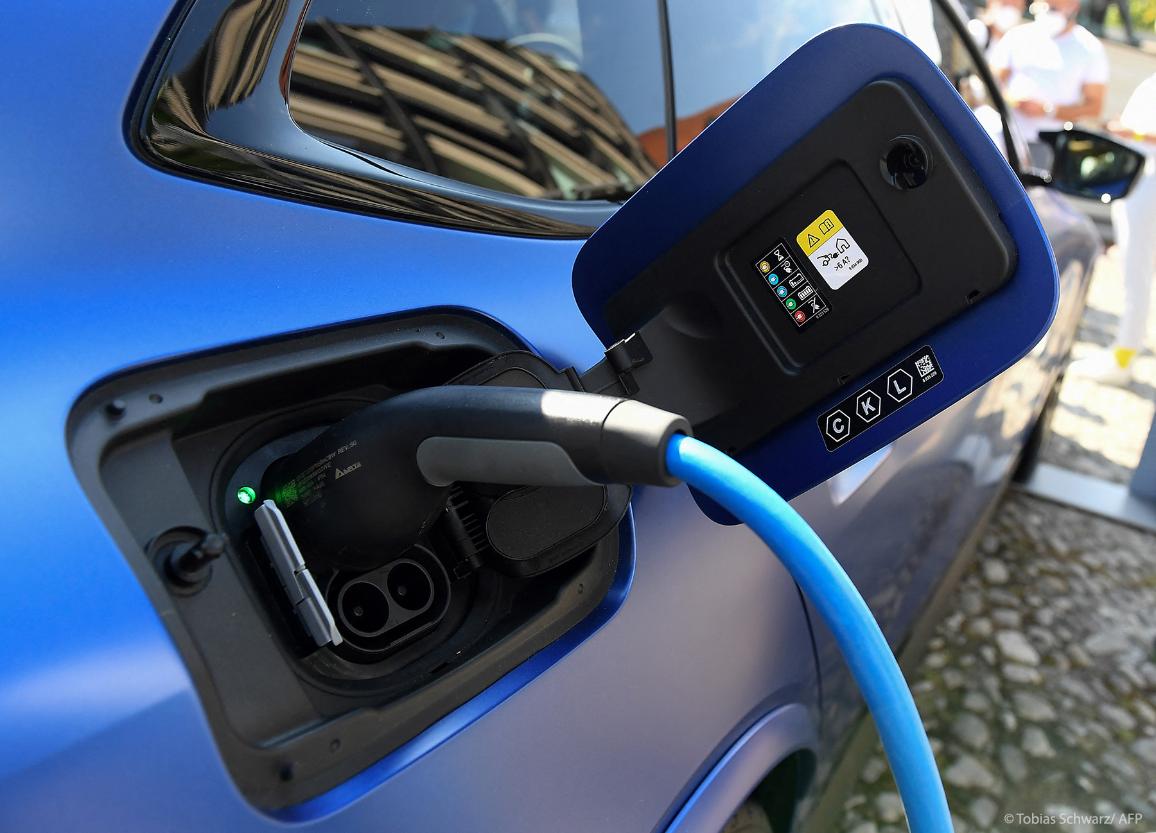Mėlynas automobilis kraunasi krovimo stotelėje.