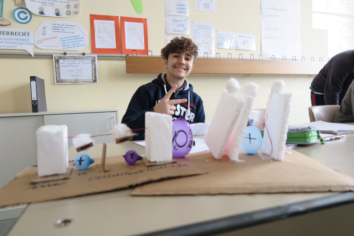 Schüler in Klassenraum bastelt Experiment