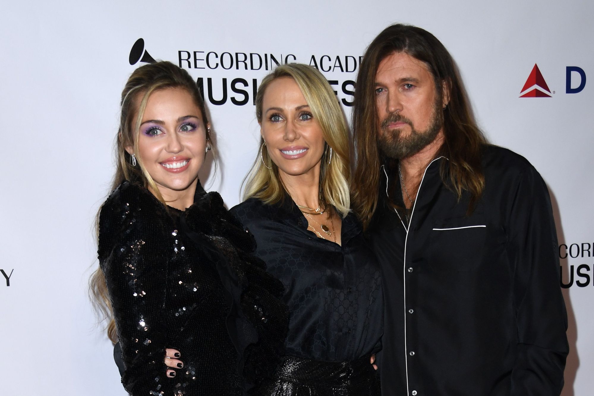 (From L) US singer Miley Cyrus and parents Tish and Billy Ray Cyrus arrive for the 2019 MusiCares Person Of The Year gala at the Los Angeles Convention Center in Los Angeles on February 8, 2019. (VALERIE MACON/AFP via Getty Images)
