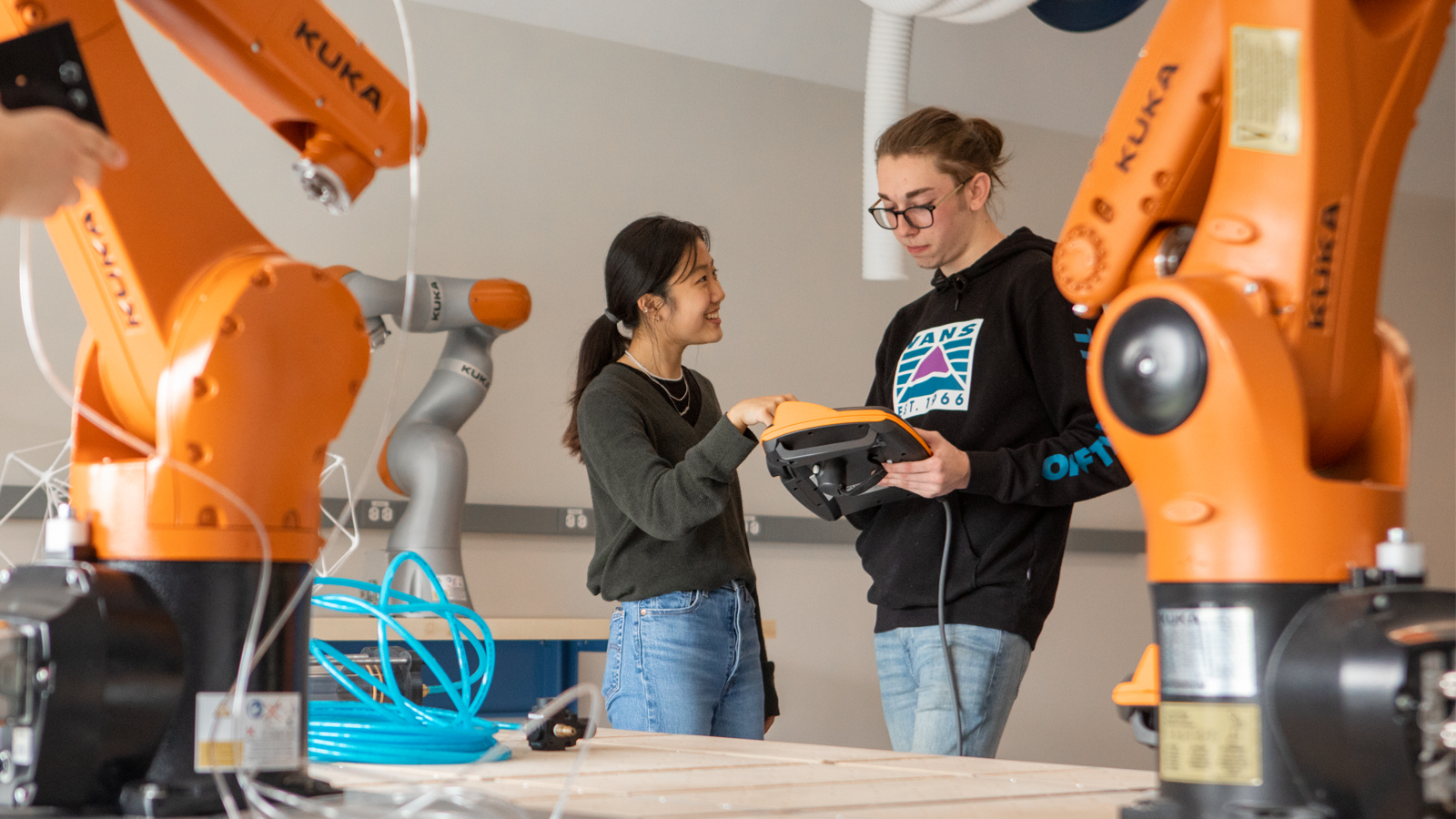 Architecture students work in the Fabrication Lab with robotics.