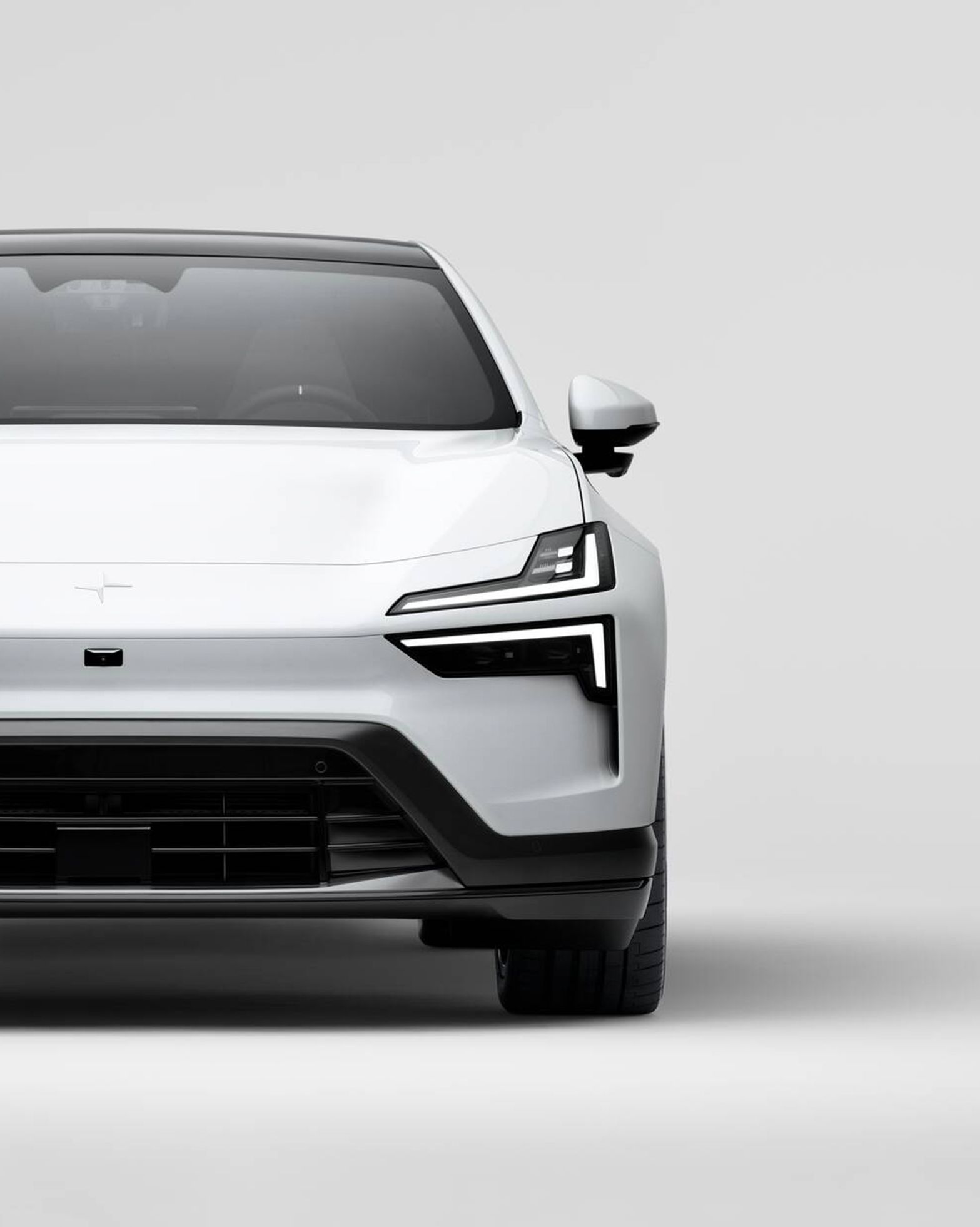 Front view of a white Polestar car with visible headlights and grille against a plain background.