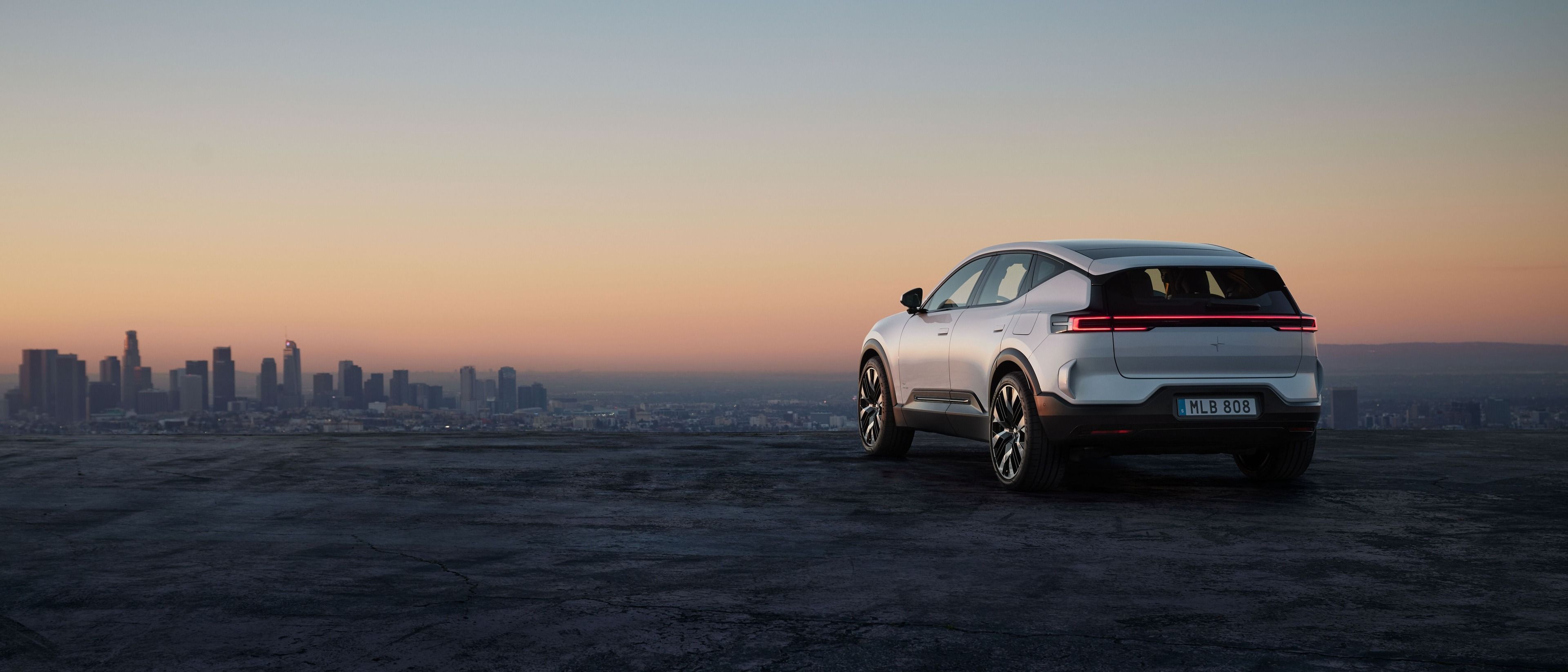 Polestar 3 rear angled view with cityscape in background at sunset