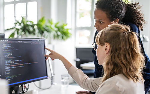 two people discussing and looking at the laptop
