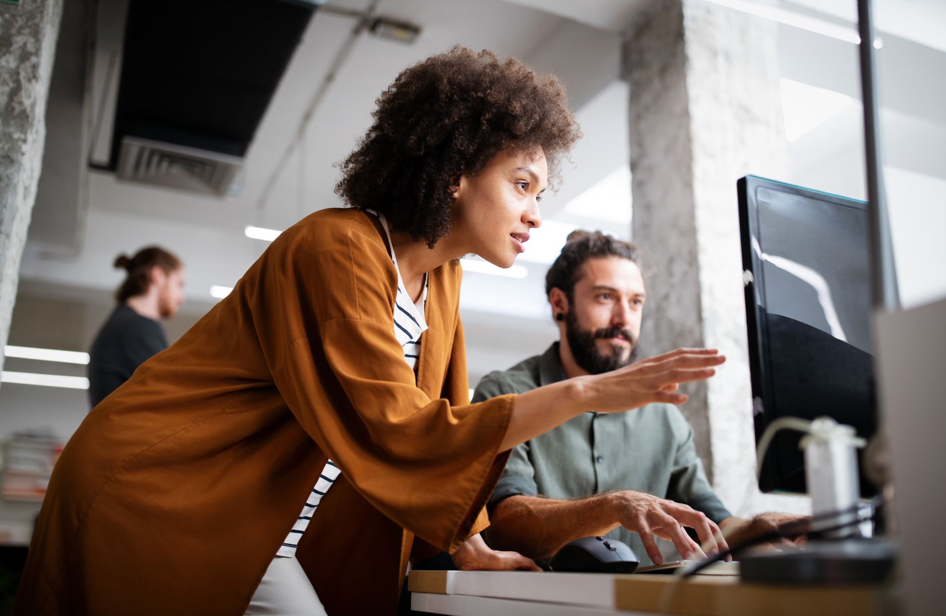 two people talking and pointing at the computer